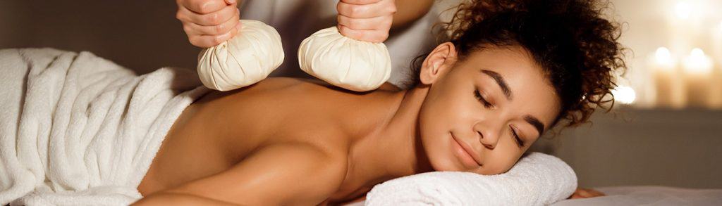 Oriental therapy. Lady receiving herbal massage at spa center